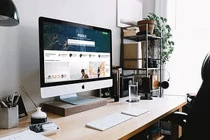 iMac on desk with example mockup of Membership site type: done for you resources.