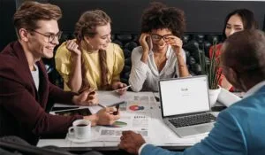 Five people at a table talking about work