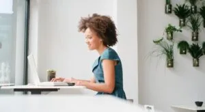 Header-solo - AccessAlly Woman sitting in front of a laptop working