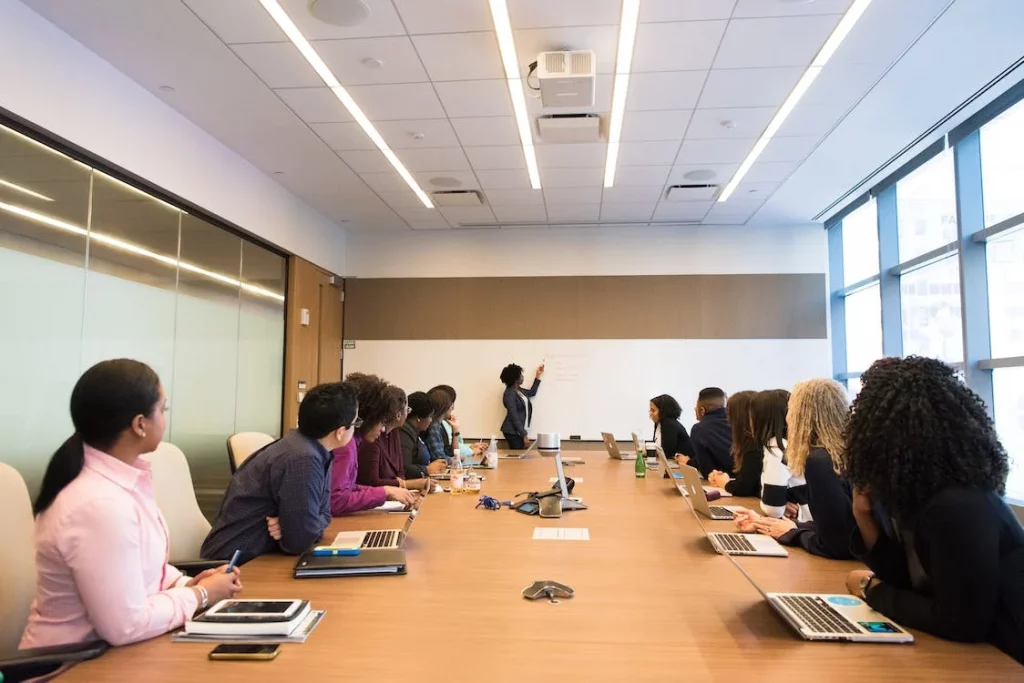 A group of people in a conference room listening to a team member speak