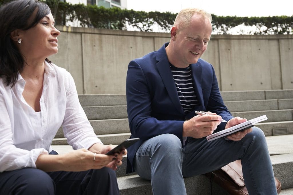 A woman and a man having a discussion while sitting on steps